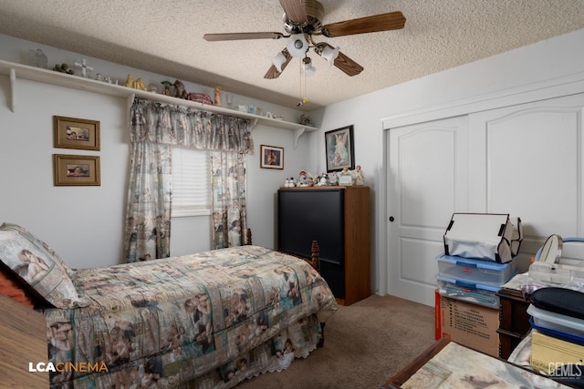 bedroom with a textured ceiling, carpet floors, a closet, and a ceiling fan