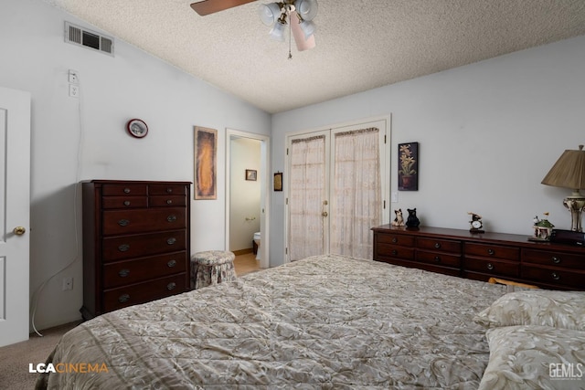 bedroom with carpet floors, visible vents, vaulted ceiling, and a textured ceiling