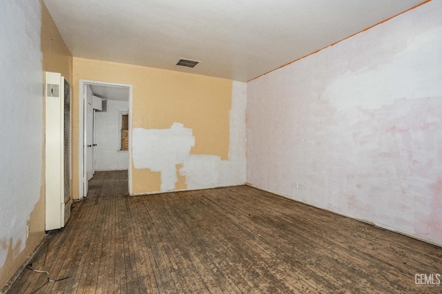 unfurnished room featuring visible vents and wood finished floors