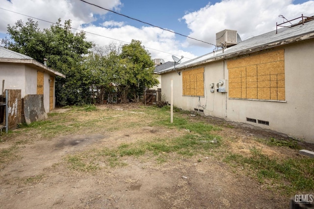view of yard featuring fence and central AC