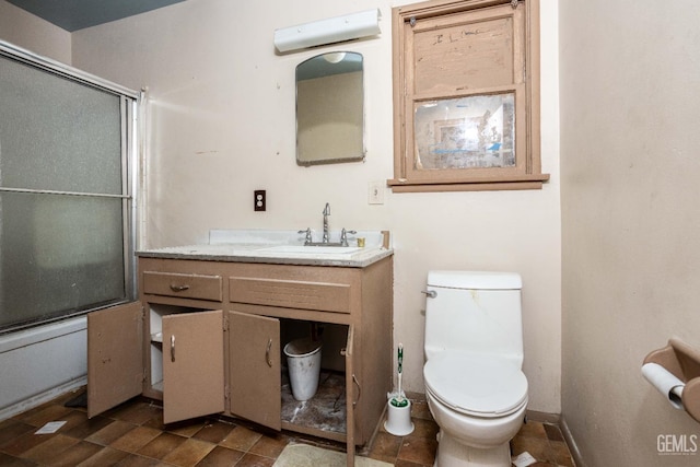 full bath with vanity, shower / bath combination with glass door, toilet, an AC wall unit, and baseboards