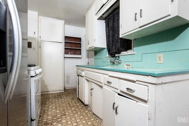kitchen with white cabinetry, light floors, tile countertops, and white appliances