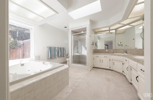 7001 Eloy Ave, Bakersfield, CA 93308 - full bath featuring a tub with jets, vanity, a skylight, and a shower stall