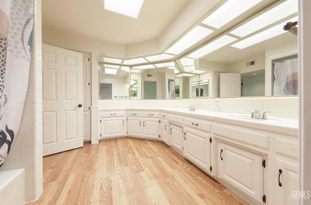 7001 Eloy Ave, Bakersfield, CA 93308 - full bathroom with a sink, visible vents, double vanity, curtained shower, and wood finished floors