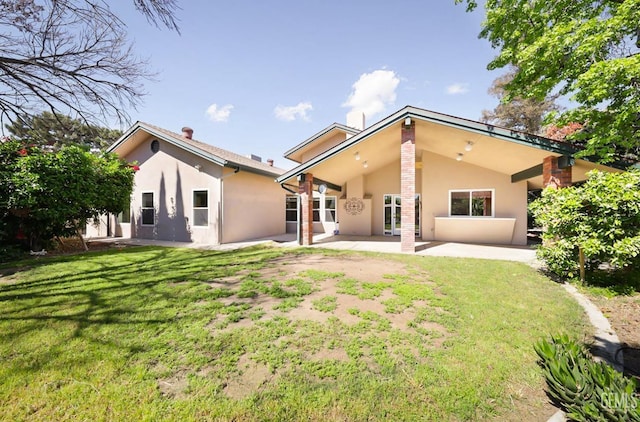7001 Eloy Ave, Bakersfield, CA 93308 - back of house with stucco siding, a patio, and a yard
