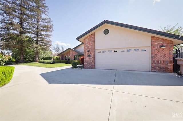 7001 Eloy Ave, Bakersfield, CA 93308 - view of property exterior with brick siding, driveway, a garage, and stucco siding