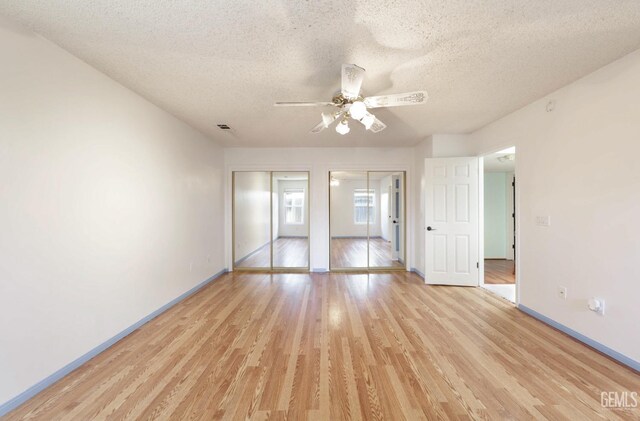 7001 Eloy Ave, Bakersfield, CA 93308 - unfurnished bedroom featuring a textured ceiling, multiple closets, baseboards, visible vents, and light wood-style floors