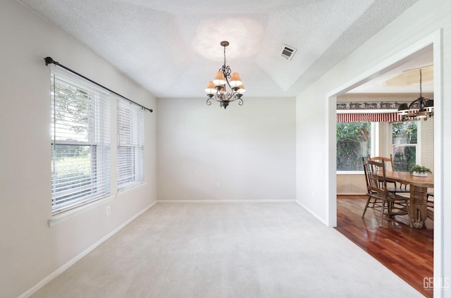 7001 Eloy Ave, Bakersfield, CA 93308 - unfurnished room with baseboards, a textured ceiling, visible vents, a notable chandelier, and wood finished floors