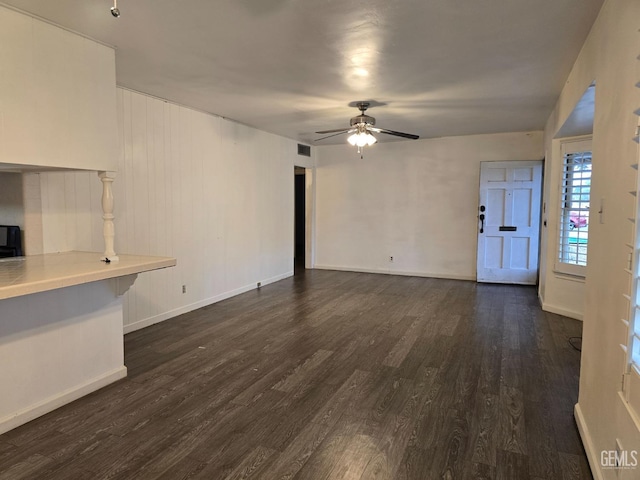 unfurnished living room with dark wood-type flooring and ceiling fan