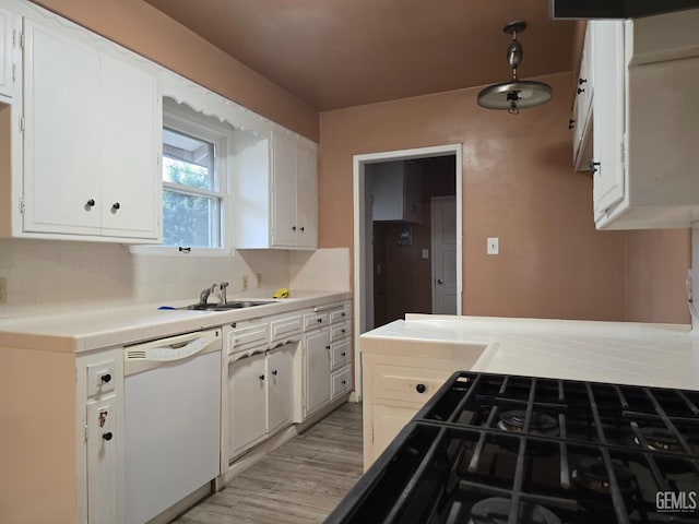 kitchen featuring white dishwasher, sink, and white cabinets