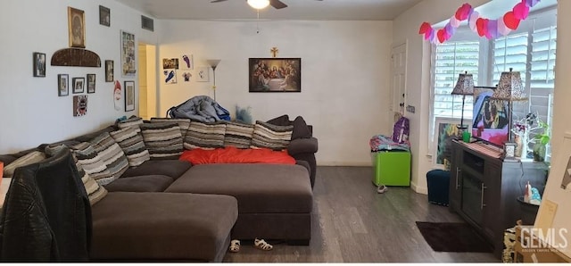 living room featuring dark wood-type flooring and ceiling fan