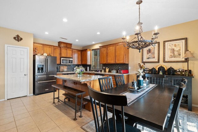 dining room featuring sink, a chandelier, and light tile patterned floors