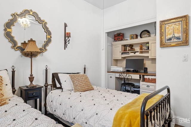 bedroom with a notable chandelier and built in desk