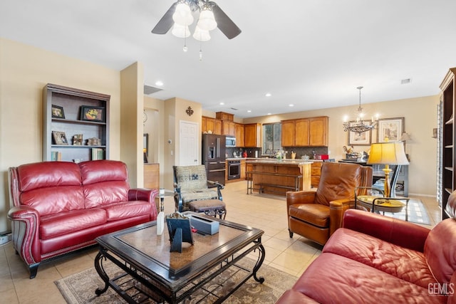 living room featuring ceiling fan with notable chandelier and light tile patterned floors