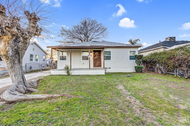 bungalow with covered porch and a front lawn