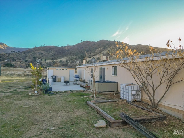 back of house with a mountain view, central AC, a patio, and a hot tub