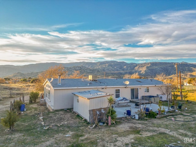 rear view of house featuring a mountain view and a jacuzzi