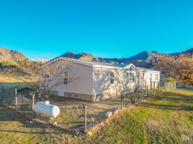 view of home's exterior with a lawn and a mountain view