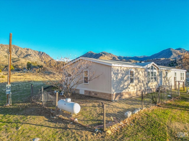 view of side of property featuring a lawn and a mountain view