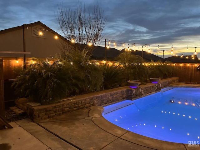 view of pool at dusk