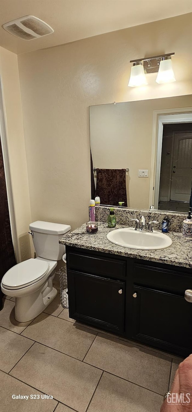 bathroom with tile patterned floors, vanity, and toilet