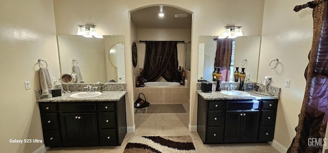 bathroom featuring vanity, tiled tub, and tile patterned flooring