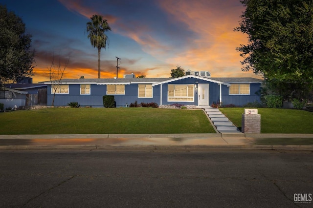 ranch-style home with a yard