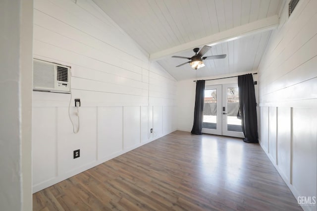 empty room featuring a wall mounted air conditioner, hardwood / wood-style floors, lofted ceiling with beams, ceiling fan, and french doors