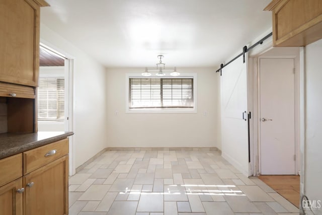 unfurnished dining area featuring a barn door