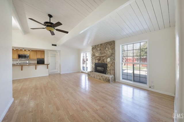 unfurnished living room featuring a healthy amount of sunlight, a fireplace, and light hardwood / wood-style flooring