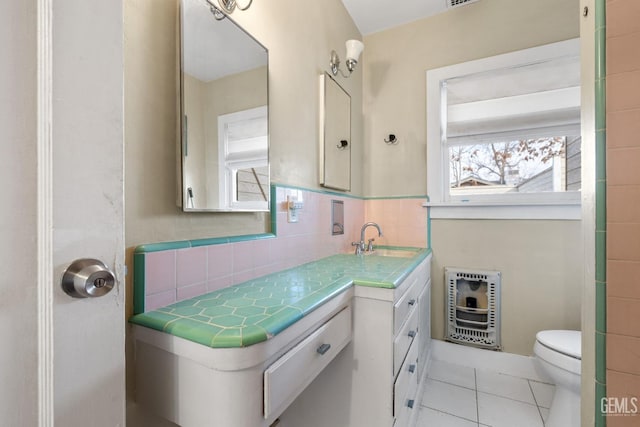 bathroom with backsplash, heating unit, vanity, tile patterned floors, and toilet