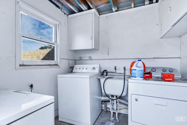 laundry area featuring separate washer and dryer and cabinets