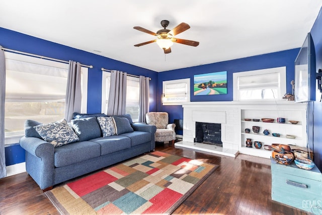 living room featuring a fireplace, dark hardwood / wood-style floors, and ceiling fan