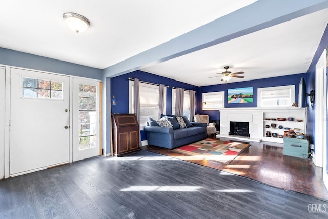 living room with dark wood-type flooring and ceiling fan