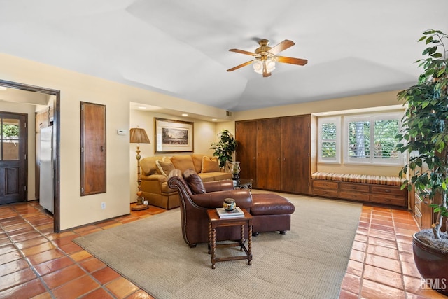 tiled living room with plenty of natural light, ceiling fan, and vaulted ceiling