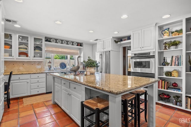 kitchen featuring a kitchen bar, white cabinets, a kitchen island, and stainless steel appliances