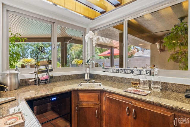 kitchen with tile patterned flooring, dishwasher, sink, and a wealth of natural light