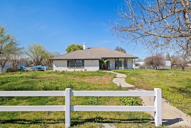 view of front of property featuring a tile roof, fence, and a front lawn