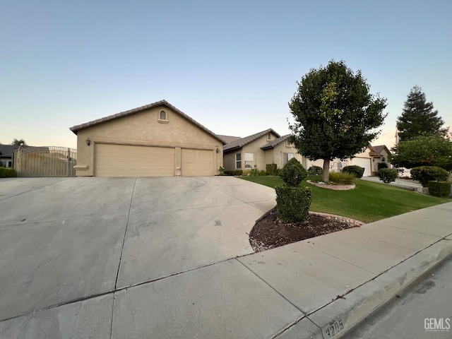 3205 Petite Sirah St, Bakersfield, CA 93306 - view of front of home featuring a garage, a front yard, stucco siding, and driveway