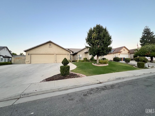 3205 Petite Sirah St, Bakersfield, CA 93306 - ranch-style house featuring a front lawn, driveway, an attached garage, a residential view, and stucco siding