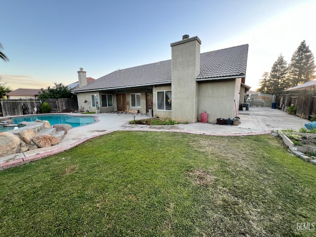 3205 Petite Sirah St, Bakersfield, CA 93306 - back of house with a patio area, a tile roof, a chimney, and a fenced backyard