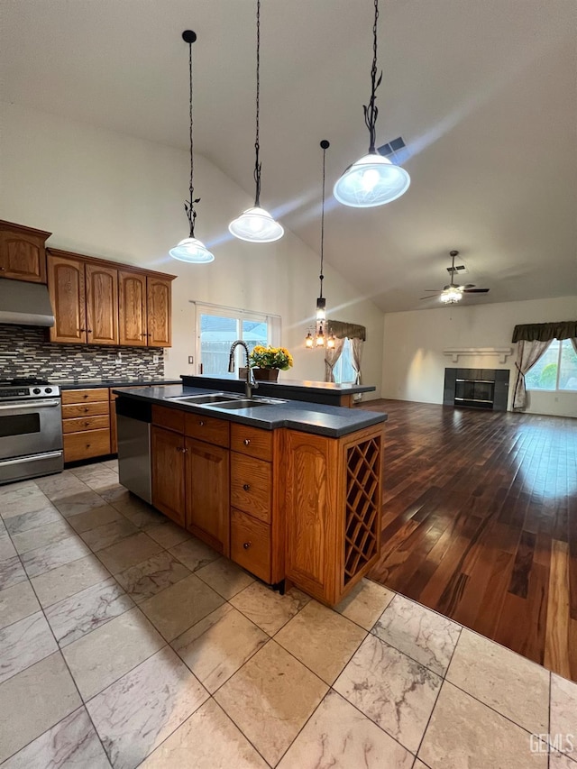 3205 Petite Sirah St, Bakersfield, CA 93306 - kitchen featuring stainless steel appliances, under cabinet range hood, dark countertops, open floor plan, and an island with sink