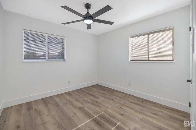 1813 6th Ave, Delano, CA 93215 - empty room with healthy amount of natural light, wood finished floors, and baseboards