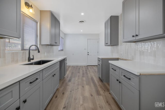 1813 6th Ave, Delano, CA 93215 - kitchen featuring a sink, gray cabinets, tasteful backsplash, light wood-style flooring, and recessed lighting