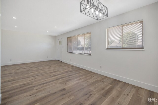 1813 6th Ave, Delano, CA 93215 - empty room featuring wood finished floors, baseboards, recessed lighting, and a chandelier