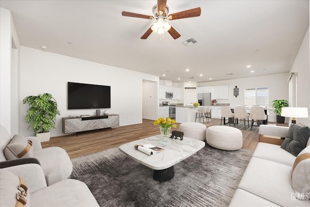 7305 Scrivia Ct, Bakersfield, CA 93311 - living room with light wood-type flooring, a ceiling fan, and recessed lighting