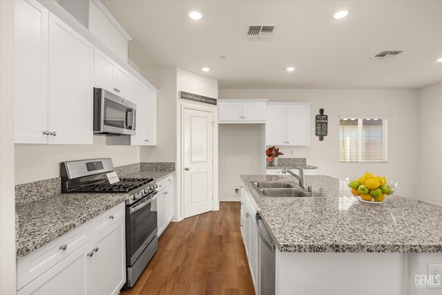 7305 Scrivia Ct, Bakersfield, CA 93311 - kitchen featuring stainless steel appliances, a sink, dark wood-type flooring, a kitchen island with sink, and white cabinetry
