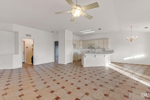 unfurnished living room featuring ceiling fan with notable chandelier and sink