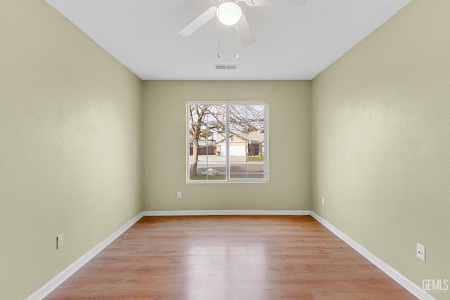 empty room with ceiling fan and light hardwood / wood-style flooring