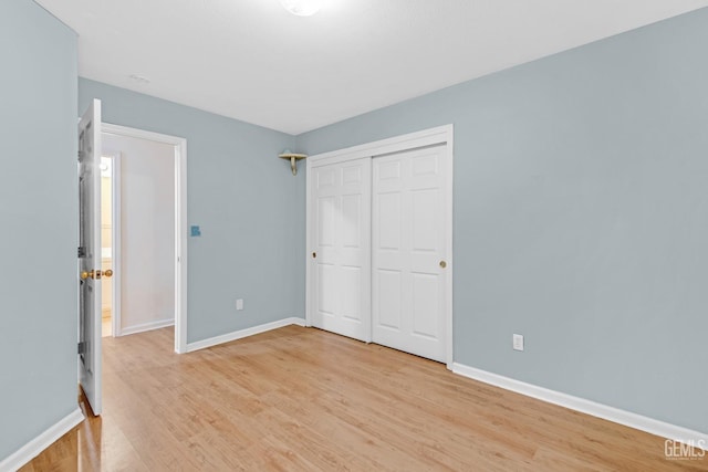 unfurnished bedroom with light hardwood / wood-style floors and a closet